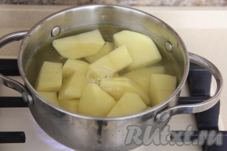 Пока тесто для вареников "отдыхает", можно заняться начинкой. Картошку нужно почистить (крупные клубни можно разрезать на части), выложить в кастрюлю, залить полностью водой, поставить на огонь. После закипания немного подсолить и варить на небольшом огне до готовности (минут 25, готовые картошины должны легко прокалываться ножом).