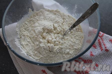 Добавить половину просеянной муки, перемешать тесто столовой ложкой.