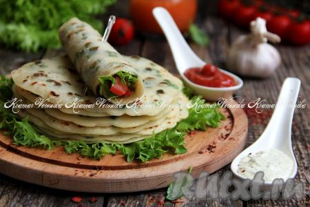 Мягкие, аппетитные постные бездрожжевые лепёшки, приготовленные с зеленью на сковороде, можно подать в качестве дополнения к супу или другим блюдам. Лепёшки получаются эластичными, поэтому в них можно заворачивать различные начинки. Отличным дополнением к ним станут различные соусы (например, томатный).