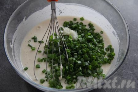 Перемешать тесто венчиком. Зелёный лук (или другую зелень) мелко нарезать, чеснок пропустить через пресс. Добавить в тесто лук и чеснок, перемешать.