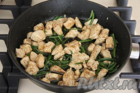 Жарить курицу со стрелками чеснока 5 минут, время от времени перемешивая. Затем влить соевый соус, перемешать и потомить на небольшом огне 2-3 минуты, периодически помешивая. В конце попробовать мясо на соль и, если нужно, подсолить.