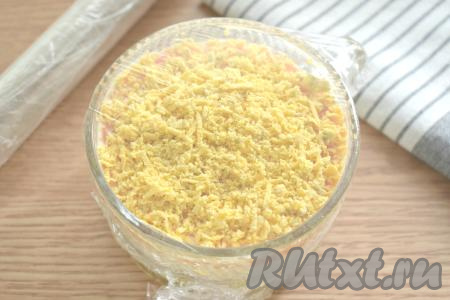 Салатник затягиваем пищевой плёнкой (или накрываем тарелкой) и убираем в холодильник, чтобы слои салата достаточно хорошо пропитались (примерно на 1 час).