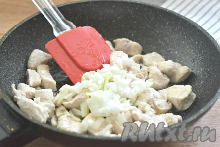 К обжаренной курице выкладываем мелко нарезанный лук, перемешиваем и обжариваем минуты 3 на среднем огне, иногда помешивая.