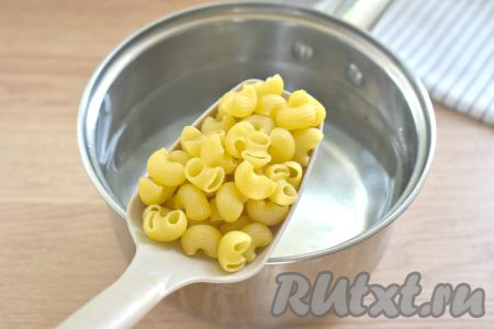 Пока мясо тушится, нужно отварить макароны, для этого в кастрюле нужно вскипятить примерно 1,5 литра воды, посолить. В закипевшую подсоленную воду выкладываем макароны любой формы, перемешиваем и варим 7-9 минут (точное время варки смотрите на упаковке макаронных изделий, которые вы готовите). Отваренные макароны откидываем на дуршлаг, чтобы слить воду, в которой они варились.