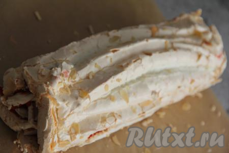 Свернуть корж с начинкой в рулет, начиная с длинной стороны.