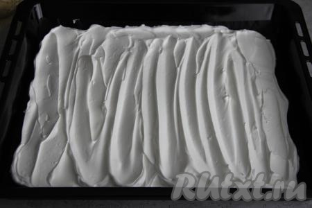 Выложить взбитые белки на противень (у меня противень размером 35 сантиметров на 40 сантиметров), застеленный ковриком (или пергаментной бумагой) для выпечки. Разровнять белковую массу силиконовой лопаткой (или ложкой) и сформировать волны.