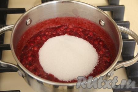 В кастрюлю с проваренными ягодами всыпать сахар, перемешать.