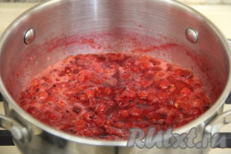 Затем ягоды из дуршлага пересыпать в кастрюлю, слегка раздавить толкушкой. Поставить на средний огонь. Довести ягоды красной смородины до кипения, а после этого варить с момента закипания на медленном огне 20 минут. Не забываем снимать пенку и периодически перемешивать ягоды.