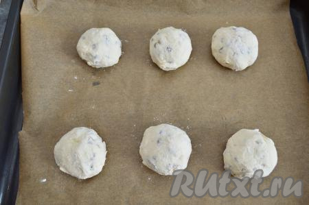 Таким образом, обязательно слегка смачивая руки водой, сформировать 6 заготовок сырников и разложить их на противень, застеленный пергаментом. Располагайте сырники на расстоянии друг от друга, в процессе выпечки они увеличатся в объёме.