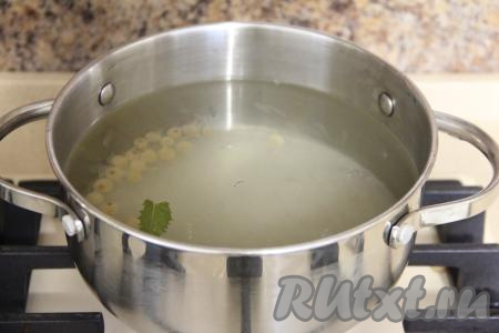 Затем воду из банок слить в кастрюлю так, чтобы ягоды, мята и лимон остались в баночках. В кастрюлю с водой, слитой из банок, всыпать сахар, перемешать и поставить на огонь, после закипания, уменьшив огонь, варить получившийся сироп 2 минуты.