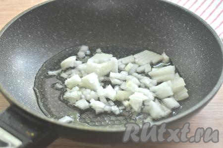 Очищаем репчатый лук и морковь. Разогреваем на сковороде растительное масло, выкладываем лук, нарезанный достаточно мелко, и обжариваем его на среднем огне, периодически перемешивая, 2-3 минуты (до прозрачности).