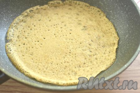 Хорошо разогреваем сковороду, смазываем её растительным маслом. Я смазывала сковороду только перед жаркой первого блинчика, так как в состав теста входит растительное масло, которого вполне достаточно, чтобы блины в дальнейшем не приставали к сковороде в процессе жарки, но многое зависит и от качества покрытия сковороды. Выливаем на сковороду половник блинного теста, равномерно распределяем и жарим блинчик на среднем огне до румяности с двух сторон (примерно по 1 минуте с каждой стороны), затем перекладываем на тарелку. Постепенно жарим все дрожжевые блины, складывая их один на другой на тарелку. Тесто в миске иногда перемешиваем.