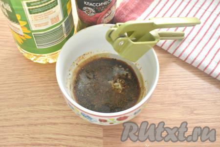 Пока картошка остывает, приготовим для неё соус. Для этого в миску вливаем растительное масло и соевый соус, добавляем очищенные зубчики чеснока, пропущенные через пресс, и специи (я взяла готовую универсальную приправу). Я использовала классический соевый соус, он достаточно солёный, поэтому картофель не солила, если любите довольно-таки солёные блюда, тогда можете добавить немного соли.