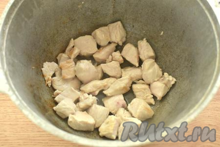 Разогреваем в казане растительное масло. В горячее масло выкладываем кусочки куриного мяса и обжариваем на среднем огне минут 7-8 (до изменения цвета филе со всех сторон), иногда перемешивая.