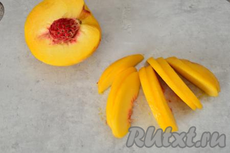Разрезать персик пополам, вытащить косточку. Нарезать половинки персика на дольки толщиной 2 миллиметра.