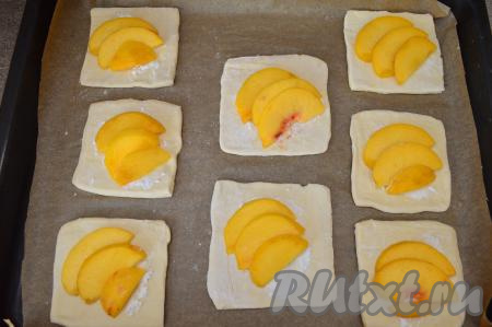 Выложить заготовку слойки на противень, застеленный бумагой для выпечки. Я использую бумагу с добавлением силикона, к ней выпечка практически не пристаёт. Если не уверены в качестве вашего пергамента, тогда предварительно смажьте бумагу тонким слоем растительного масла. Если неудобно переносить заготовку слойки с начинкой на противень, тогда можно выкладывать слегка раскатанные квадратики теста на застеленный противень, а затем уже на тесто раскладывать ломтики персика - здесь уже кому как удобно. Постепенно сформировать все 8 заготовок слоек со свежими персиками.