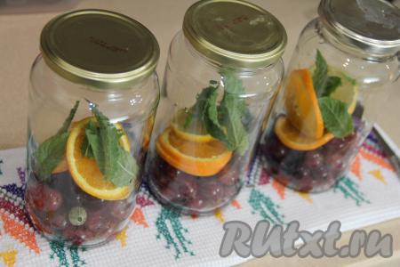 Банки (у меня - 3 банки&nbsp;объёмом по 800 миллилитров) простерилизовать любым удобным для вас способом (я простерилизовала в посудомойке). Крышки прокипятить 3 минуты с момента закипания воды. Апельсин и лимон нарезать на кружочки вместе с кожурой. Косточки из цитрусовых удалить. В каждую банку выложить 200 грамм ягод, 2 кружочка апельсина, 1 кружочек лимона и 3-5 листочков мяты.
