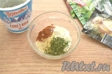 В небольшую миску выкладываем сметану, добавляем к ней специи (у меня - паприка, сушёный чеснок, сушёная зелень) и соль по вкусу. Вы можете использовать свои любимые специи или приправы.