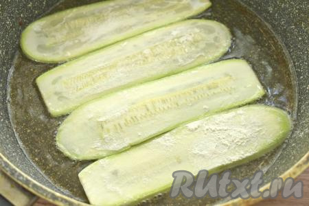 Разогреваем на сковороде растительное масло, выкладываем пластины из кабачка в один слой и обжариваем их до подрумянивания с двух сторон (примерно по 2-3 минуты с каждой стороны) на среднем огне.