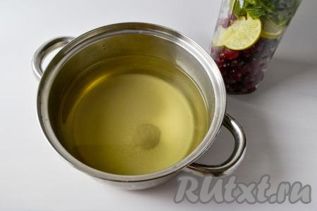 Слейте воду из бутылки так, чтобы ягоды, лайм и мелисса остались в бутылке. Перемешайте сахар с водой в кастрюле, поставьте на достаточно сильный огонь и доведите ягодный отвар до кипения.