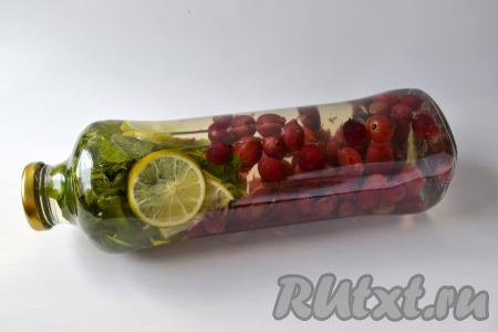 После закипания, уменьшив огонь, проварите ягодный отвар 2-3 минуты, чтобы сахар полностью растворился. Затем горячий отвар влейте в бутылку с крыжовником и мелиссой, сразу закрутите крышкой. Переверните бутылку, чтобы проверить герметичность закрытия.