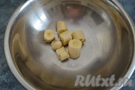 В глубокую миску выложить очищенный банан, разломанный на кусочки.