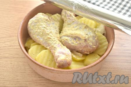 Поверх картошки с луком выкладываем куриные голени, замаринованные в майонезе. Форму накрываем фольгой и отправляем в духовку, разогретую до 180-190 градусов, на 50 минут. Затем фольгу убираем и запекаем ещё 15 минут.