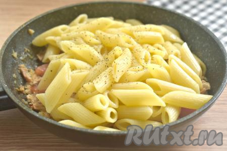 Макароны тем временем сварились, откидываем их на дуршлаг, даём стечь воде. Перекладываем макароны на сковороду к свиной тушёнке, перчим на свой вкус, перемешиваем.