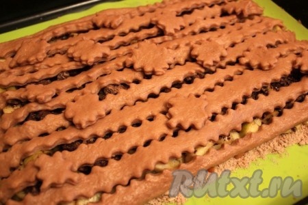 Выложить полоски и фигурки на начинку и выпекать песочный пирог с яблоками и шоколадом в разогретой духовке при 180 градусах около получаса.