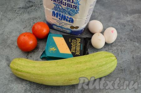 Подготовить продукты для приготовления кабачковой запеканки с сыром и помидорами в духовке. Сыр можно взять твёрдых или полутвёрдых сортов. Вес кабачка указан в неочищенном виде.