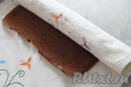 Горячий корж сразу перевернуть на хлопчатобумажное полотенце, снять пергамент. Корж вместе с полотенцем свернуть в рулет, начиная с узкой стороны, и оставить минут на 20.