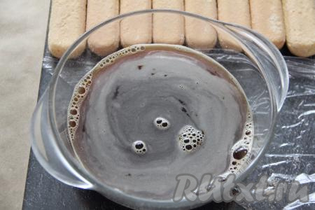 В достаточно глубокую ёмкость влить 300 миллилитров горячей воды, всыпать 2 чайных ложки растворимого кофе, тщательно перемешать и оставить кофе остывать.