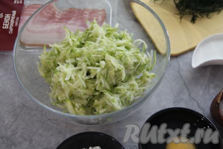 Натереть подготовленные кабачки на крупной тёрке, хорошо присолить, перемешать, оставить на 3 минуты, а затем отжать с них лишний сок (можно отжать сок, просто беря в руку часть кабачковой массы и отжимая лишнюю влагу).