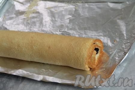 Свернуть корж с черникой в плотный рулет, начиная с широкой стороны. Завернуть бисквитный рулет в фольгу (или пергамент) и убрать на ночь в холодильник.