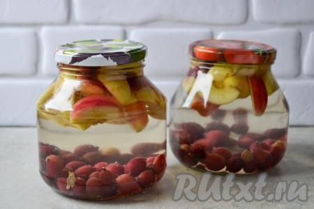 Заполните банки с крыжовником и яблоками до самого верха кипящей водой, прикройте крышками и оставьте на столе на 20-25 минут, чтобы баночки прогрелись.