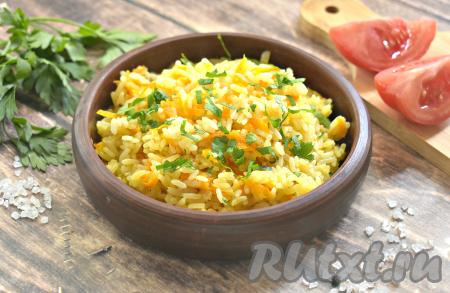 Достаём форму из духовки, перемешиваем рис с луком и морковью, украшаем свежей зеленью и подаём к столу в качестве гарнира к мясу, рыбе или птице. Рис получается рассыпчатым, а морковь с луком идеально дополняют его.