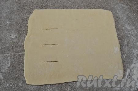 Вначале один прямоугольник раскатать до толщины 1,5-2 миллиметра. У меня получилась заготовка размером примерно 15 на 16 сантиметров. Сделать три надреза длиной примерно по 2 сантиметра ближе к одному из краёв теста.