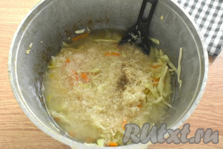 Вливаем тёплую кипячёную воду, немного увеличиваем огонь, а после закипания воды, уменьшив огонь до минимума, тушим капусту с рисом 20 минут под крышкой.