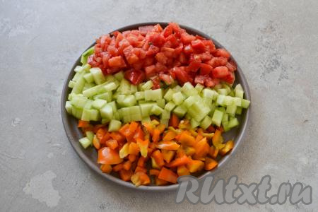 Если у огурца толстая кожура, тогда срежьте её. Из болгарского перца удалите плодоножку с семечками. Вымойте помидор, огурец и перец, нарежьте на мелкие кубики. Петрушку тоже промойте водой.