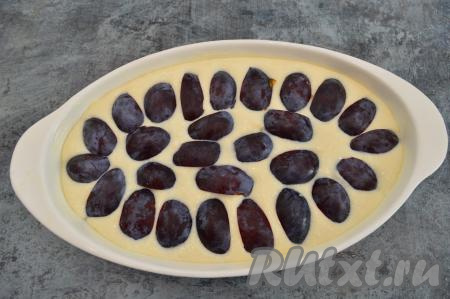 Дно и бока формы для выпечки смазать сливочным маслом (у меня форма овальная размером 16 на 26 сантиметров). Тесто для запеканки ещё раз хорошо перемешать и вылить в подготовленную форму. Кусочки слив разместить сверху, чуть утопив. Кожица должна быть сверху. Поставить форму в хорошо разогретую духовку.