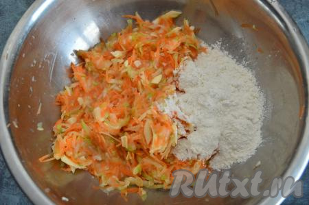 Смешать кабачки, морковку, яйца и сыр до однородности. Всыпать щепотку сахара и половину муки, перемешать кабачково-морковное тесто столовой ложкой.