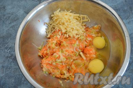 В миску с овощами, отжатыми от выделившегося сока, вбить сырые яйца и всыпать натёртый на крупной тёрке сыр.