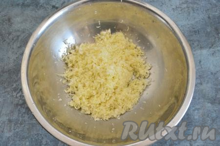 Натереть на средней тёрке цветную капусту. Капуста должна быть натёрта достаточно мелко, иначе крупные кусочки цветной капусты не успеют прожариться и будут сырыми.