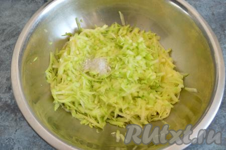 Кабачок очистить от кожуры, если семечки крупные, тогда их тоже нужно будет удалить вместе с мякотью. Натереть 600 грамм подготовленного кабачка на крупной тёрке, всыпать половину чайной ложки соли, перемешать и оставить минут на 10, чтобы кабачок выделил сок.