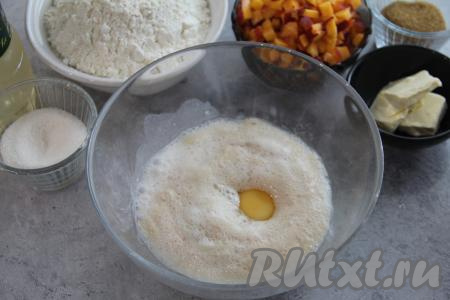 Влить в объёмную миску запенившуюся опару, добавить кефир комнатной температуры и яйцо.