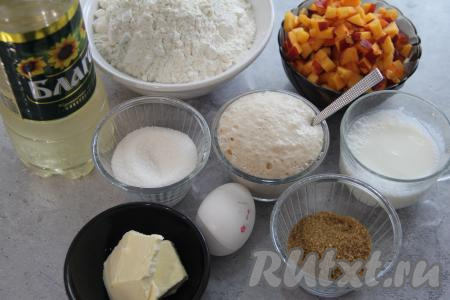 Подготовить продукты. В небольшую ёмкость влить 50 миллилитров воды, подогретой до 38-40 градусов, всыпать дрожжи и 1 чайную ложку сахара (сахар берём из общего количества сахара, указанного для замешивания теста), очень хорошо перемешать и оставить опару минут на 10 (до появления на поверхности пышной пенной шапки). Вымыть персики, удалить косточки. Нарезать персики на мелкие кубики. Для начинки для булочек потребуется примерно 300 грамм нарезанных персиков. Сливочное масло для начинки должно быть комнатной температуры, поэтому его нужно будет достать из холодильника заранее.