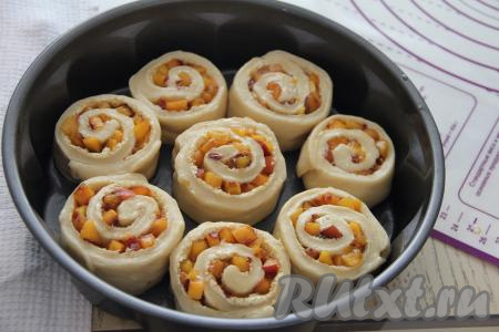 У меня получилось 8 булочек. Круглую форму (или противень) смазать маслом, выложить заготовки булочек с персиками на небольшом расстоянии друг от друга и оставить в тёплом месте минут на 35 для расстойки.