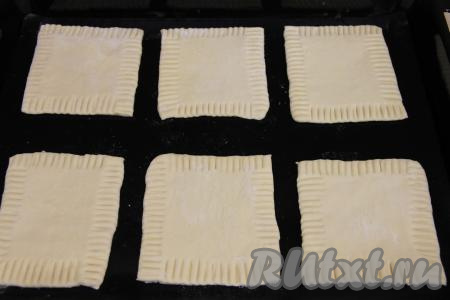 Переложить заготовки теста на противень, заранее застеленный ковриком (или пергаментом) для выпечки. Края теста слегка вдавить вилкой.&nbsp;