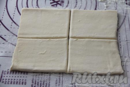 Разморозившееся тесто выложить на слегка присыпанную мукой поверхность, слегка раскатать. Разрезать каждый слегка раскатанный пласт теста на 4 квадрата. Из двух пластов теста у нас получатся 8 заготовок.