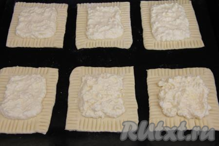 Получившуюся творожную начинку зрительно разделить на 8 частей. Выложить на середину каждой заготовки часть творожной начинки, разровнять, не заходя на края, придавленные вилкой.